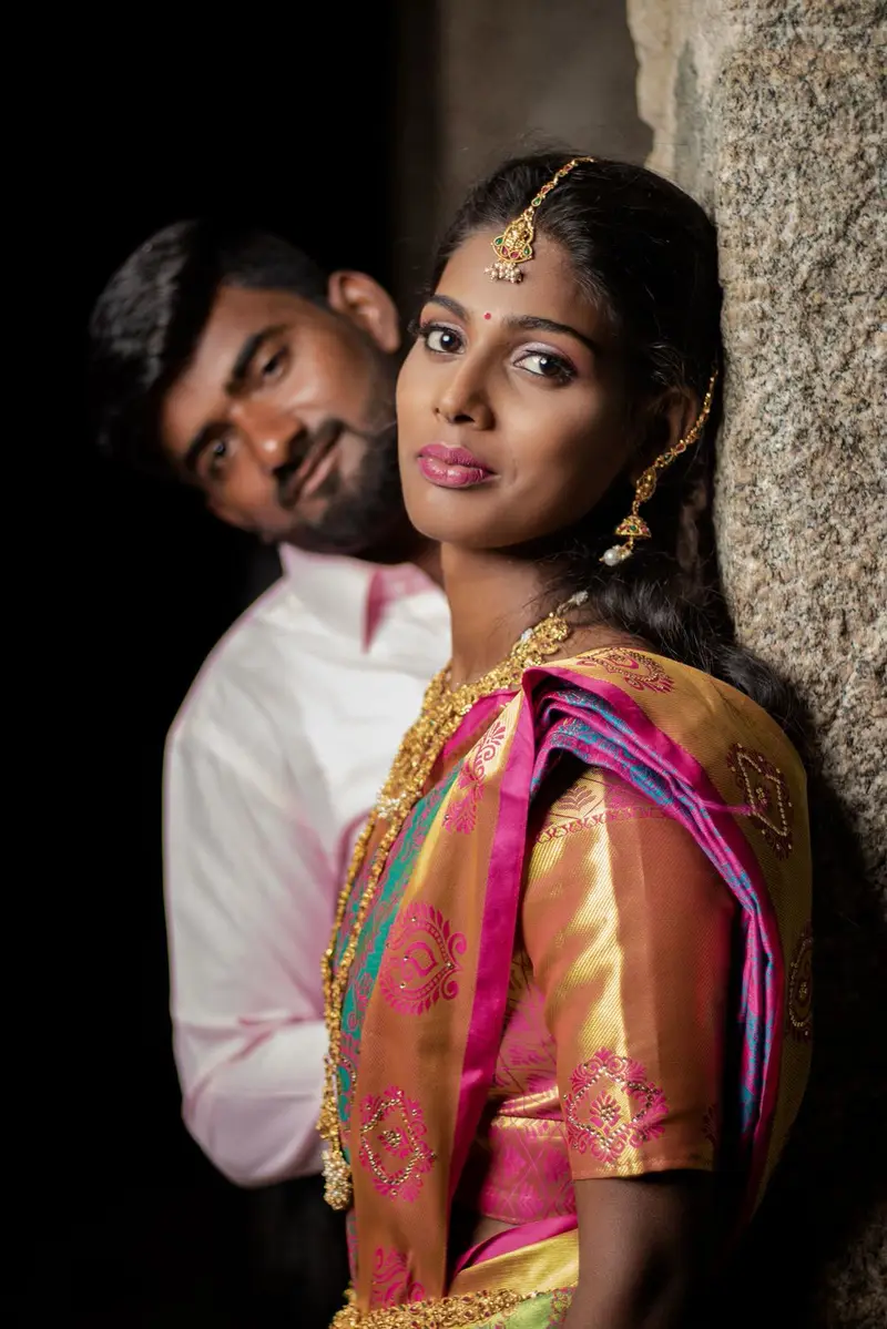 Album page: the groom close behind the bride, against dark stone