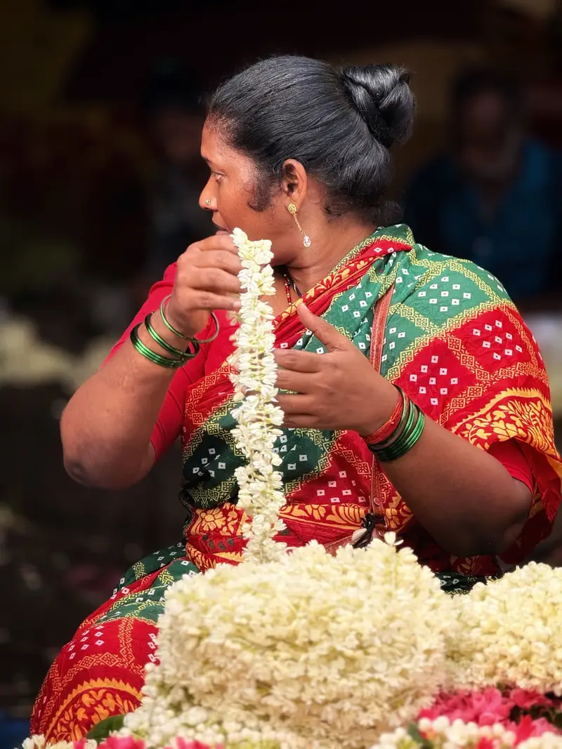A woman weaving a jasmine garland.