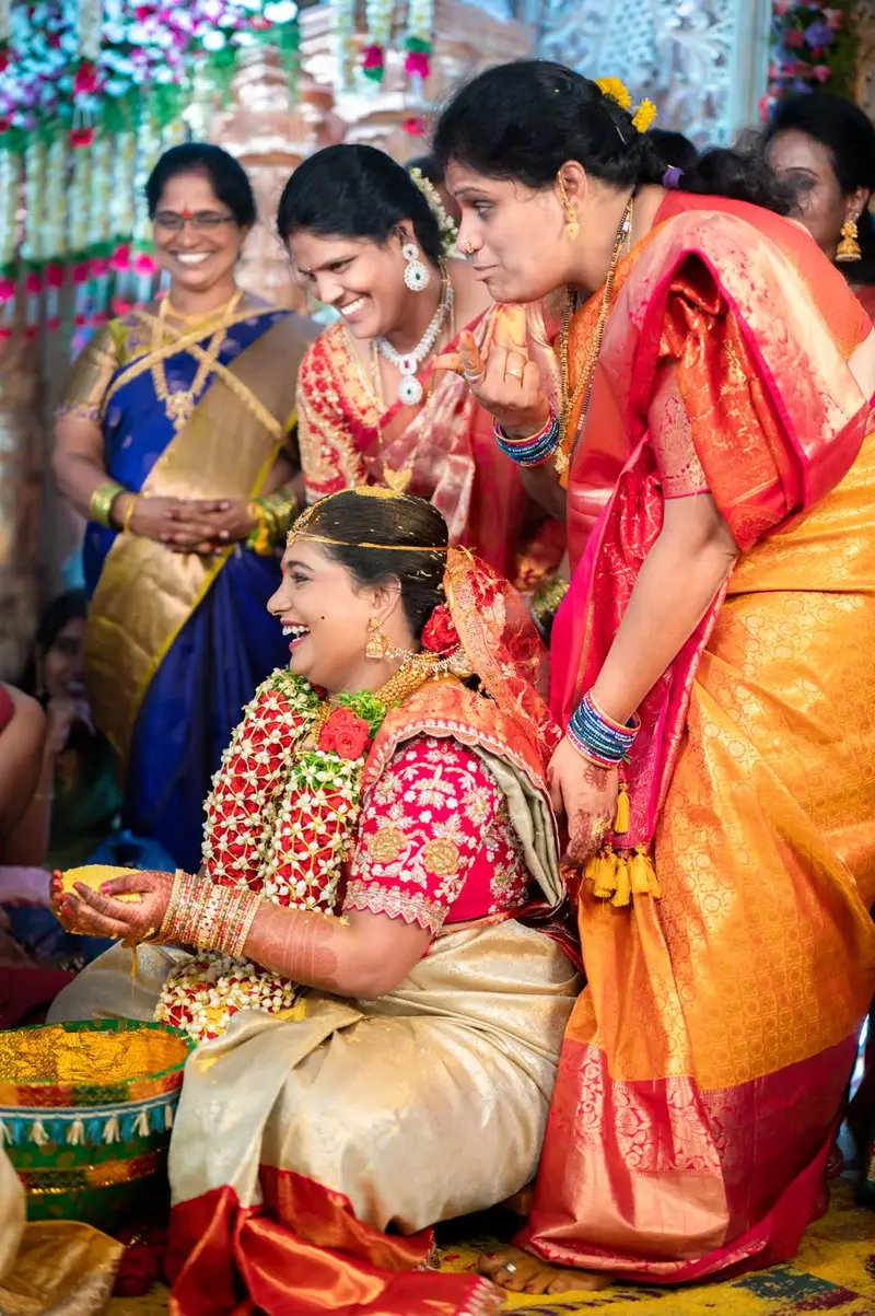 Elder women in pattu sarees around a bride.