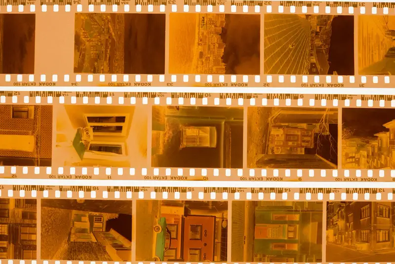 strips of colour negatives glowing amber on a light table