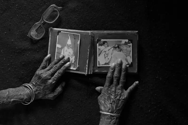 an elder's hands turning an old album (black and white)