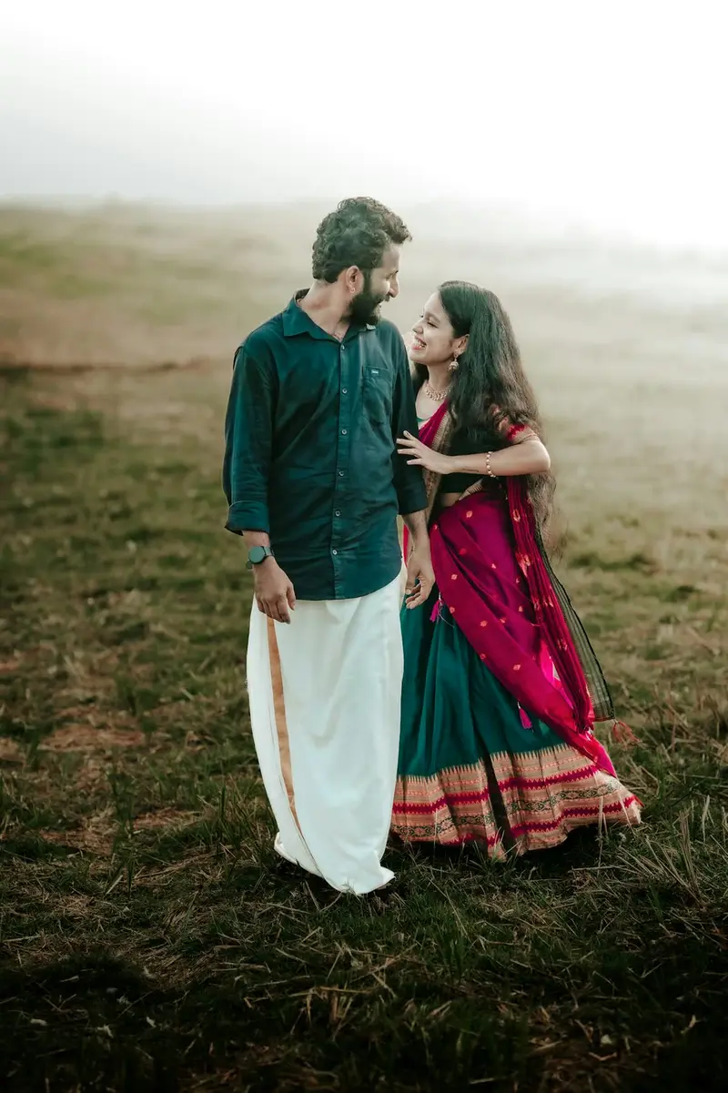 A couple on a misty hillside in tall grass.