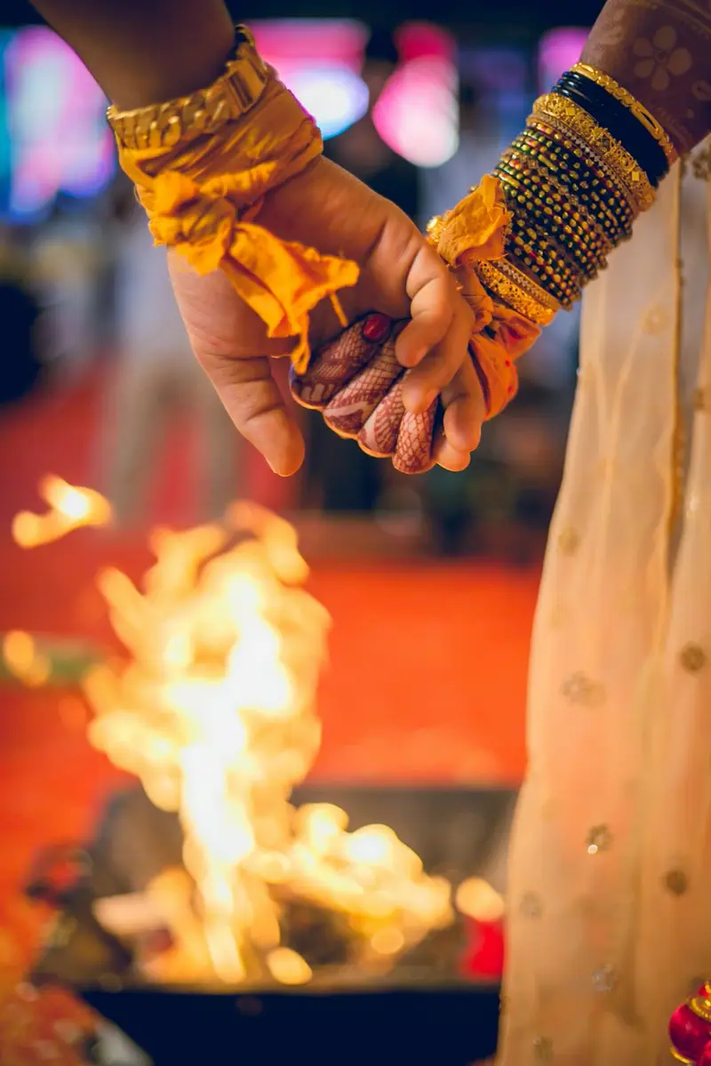 the couple's hands over the homam fire