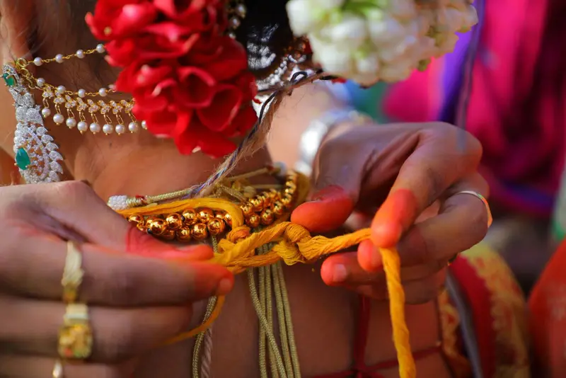 hands tying the mangalsutra knot; bangles