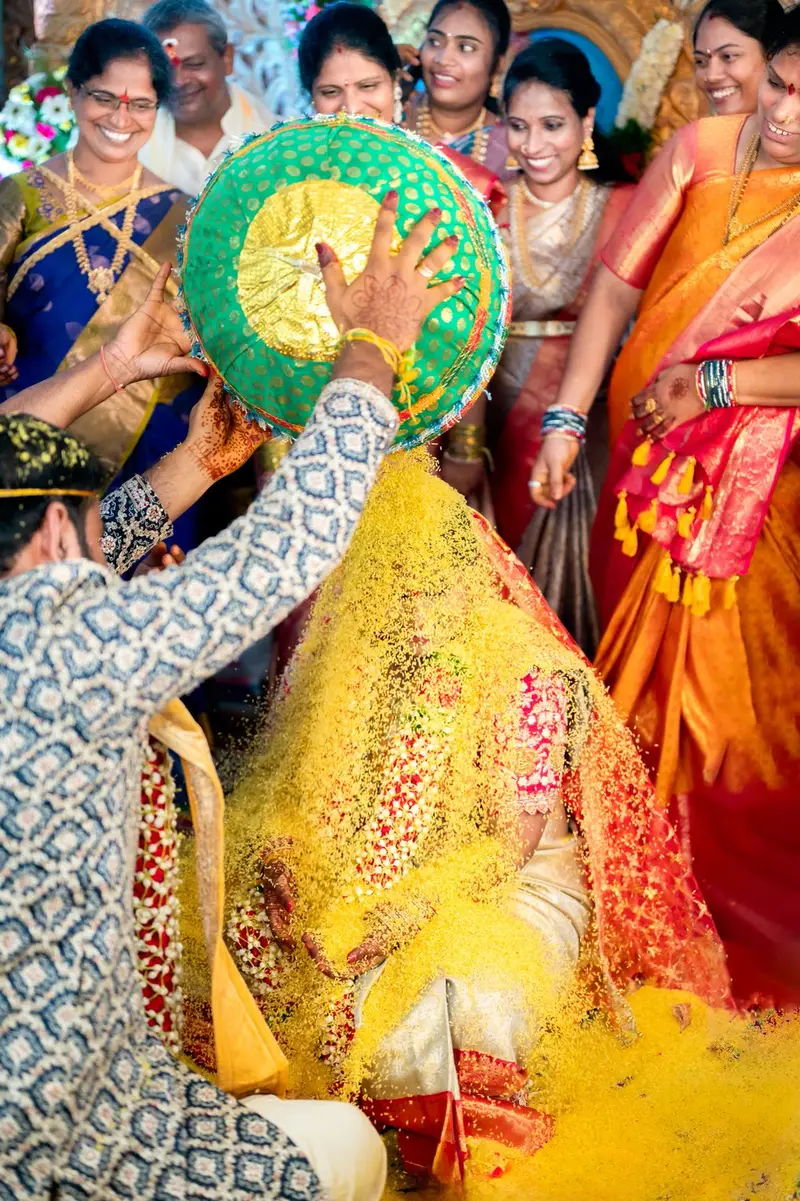 women of the family pouring rice from above; colourful